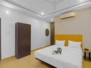 A hotel room with a bed, a wardrobe, an air conditioning unit, and a bedside table with a phone. - Classic Che Sigma (Hyderabad)