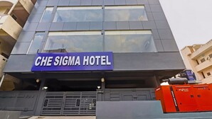 A modern hotel building with a sign reading 'CHE SIGMA HOTEL'.