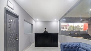 A reception area with a black desk, a blue sofa, and a door with a unique design.