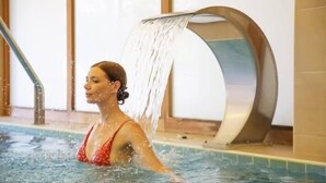 Una persona en una piscina con una fuente moderna.