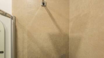 Ein Duschbereich mit einer eckigen Duschbrause, einer Handbrause und einem am Wand montierten Wasserhahn.