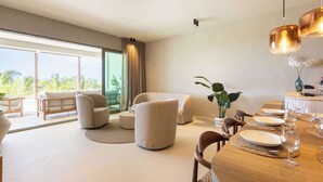 A modern living room with a dining area, large windows, and a view of the outdoors. - Private Pool Escape - Luminara at The Reef (Sint Michiel)
