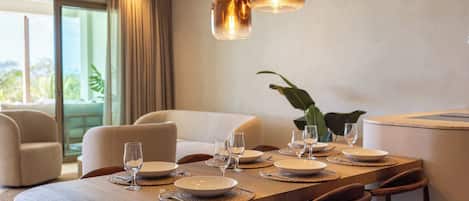 A dining area with a wooden table set for six, surrounded by upholstered chairs.