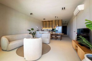 Ein modernes Wohnzimmer mit einer Couch, einem Couchtisch und einem Essbereich mit Tisch und Stühlen.