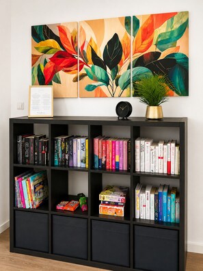 A bookshelf with various books and a framed certificate. - Premium Apartment - 90 m² - Downtown, near the city park (Pfaffenhofen an der Ilm)