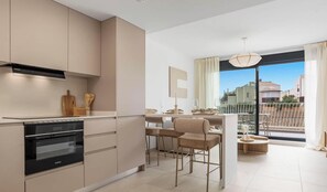 Eine moderne Küche mit integrierten Geräten, ein Essbereich mit Blick und ein Balkon mit Geländer.