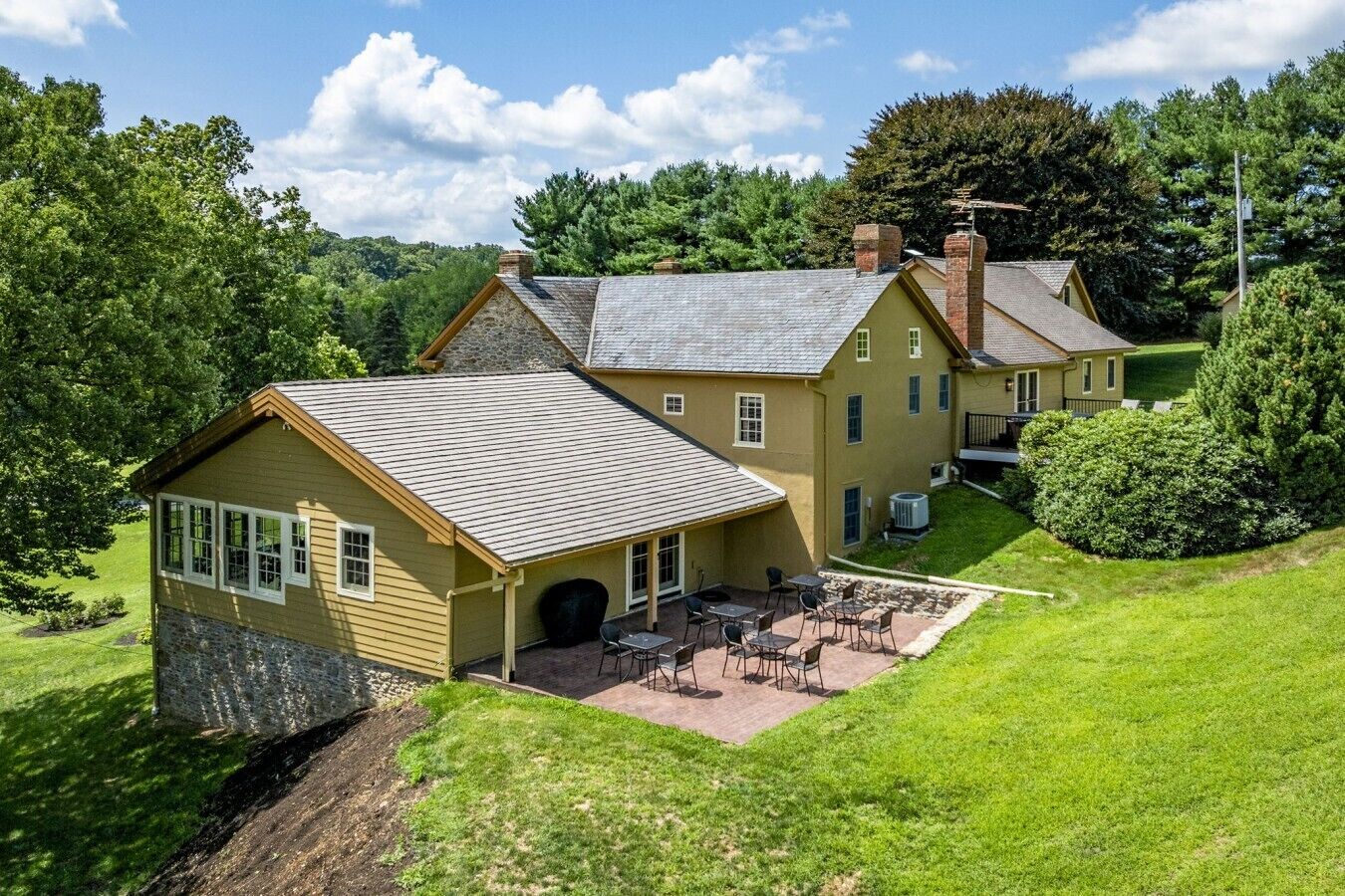 Une maison à deux étages avec un patio et une pelouse.