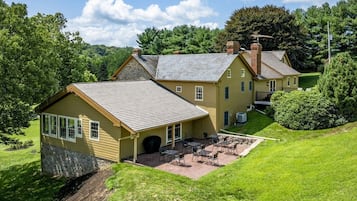 Une maison à deux étages avec un patio et une pelouse.
