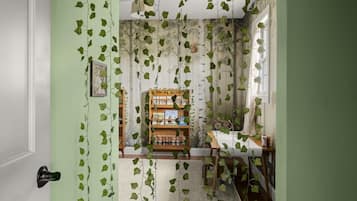 A room with a green wall, a wooden bookshelf, and a dining table with chairs.