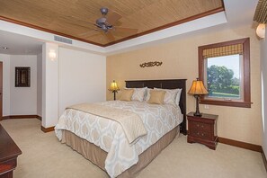 Ein Schlafzimmer mit einem großen Bett, zwei Nachttischlampen, einem Deckenventilator und einem Fenster mit Blick.