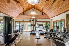 Un gimnasio con cintas de correr, bicicletas estáticas y máquinas de pesas.