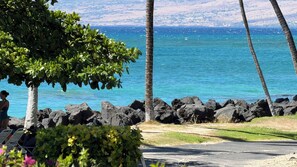 Une vue sur la côte, avec un ciel dégagé, une côte rocheuse et une personne assise sur une chaise.