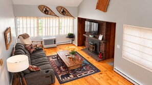 Ein modernes Wohnzimmer mit Sofa, Couchtisch und Kamin.