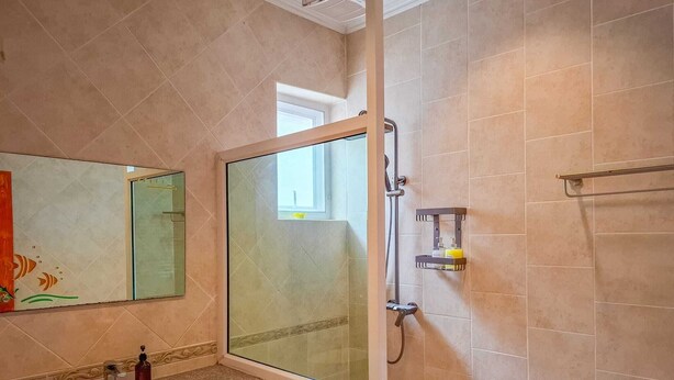A bathroom with a glass shower enclosure, a sink, and a mirror. - Beachside 4BR Private Pool Villa  (Muang Pattaya)