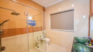 A modern bathroom with a glass-enclosed shower, a toilet, and a sink with a green glass basin. - Beachside 4BR Private Pool Villa  (Muang Pattaya)