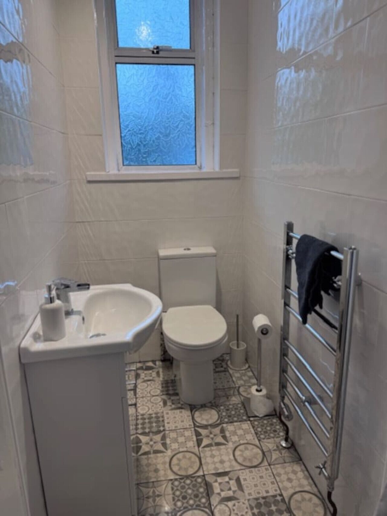 Ein kleines Badezimmer mit Toilette, Waschbecken und Fenster.