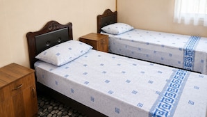 Two single beds with headboards, wooden nightstands, and a patterned bedspread. - Lake Sevan Private Cottage with Yard (Shoghakat)