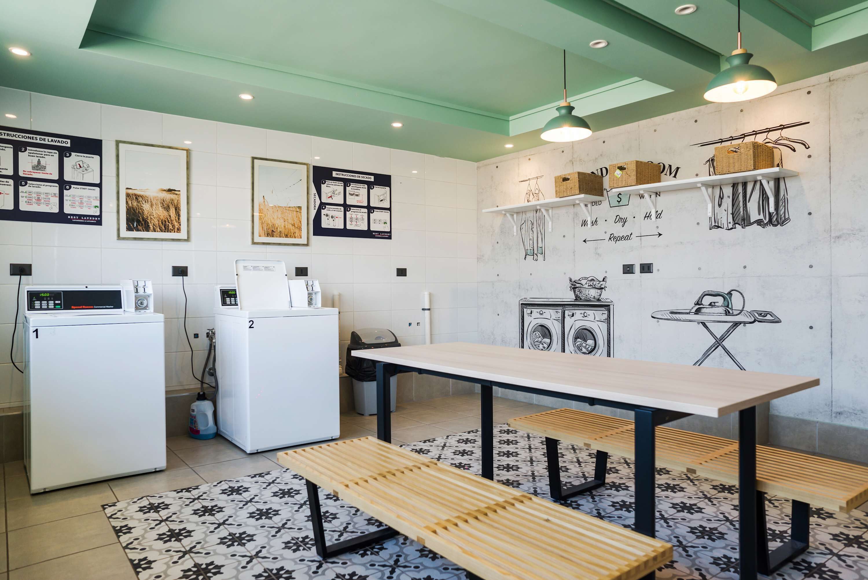A modern kitchen with a dining area, including a table and benches, a washing machine, and a refrigerator.