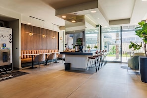 A modern bar area with seating and a coffee station.