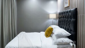 A hotel room with a bed, a lamp, and a framed picture on the wall. - The Seamless Oasis (Cape Town)