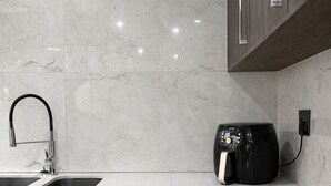 A modern kitchen with a double sink, a built-in range hood, and a countertop with a coffee machine. - The Seamless Oasis (Cape Town)
