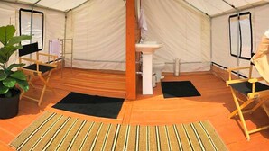 A tent with a central pillar, a sink, and foldable chairs. - Pet-Friendly and Gorgeous Safari Tent for a Glamping Getaway near White River National Forest, Colorado (Carbondale)