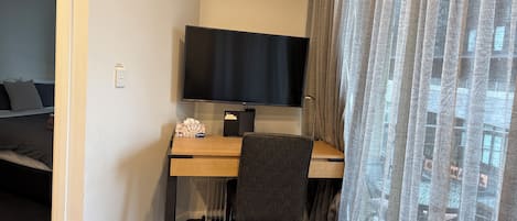 Una habitación de hotel con escritorio, televisión y cama.