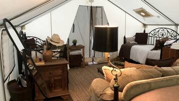 Interno di una tenda con un letto, una scrivania e una lampada.