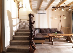 A staircase with a wooden handrail, a sofa, a coffee table, and a hanging light fixture. - Villa Okalia – Private Pool, 100m from Kalamaki Beach (Kalamaki)