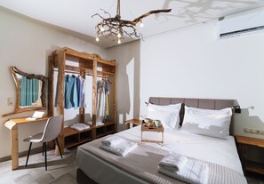 Een slaapkamer met een bed, een bureau, een stoel, een kledingkast en een hanglamp.