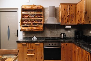 A kitchen with wooden cabinets, a stainless steel stove, and a built-in oven. - Villa Okalia – Private Pool, 100m from Kalamaki Beach (Kalamaki)