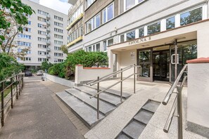 Entrada de um edifício com uma escadaria que leva a uma porta com a inscrição 'SMOLNA 8'.