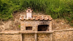 A stone-built structure with a tiled roof and two small windows.