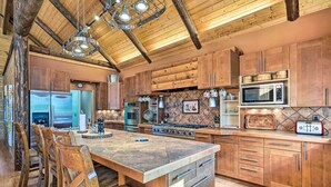 A spacious kitchen with wooden cabinets, a large island, and modern appliances. - Luxe Prescott Natl Forest Home w/ Huge Deck (Prescott)