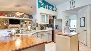A modern kitchen with a large island, stainless steel appliances, and a variety of decorative items.