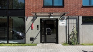 A building entrance with a glass door, a fire alarm, and a sign indicating the address. - Apartamenty Sun & Snow Old Podgórze (Kraków)