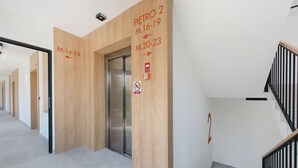 Un interior moderno con una pared de madera, un ascensor y una escalera.