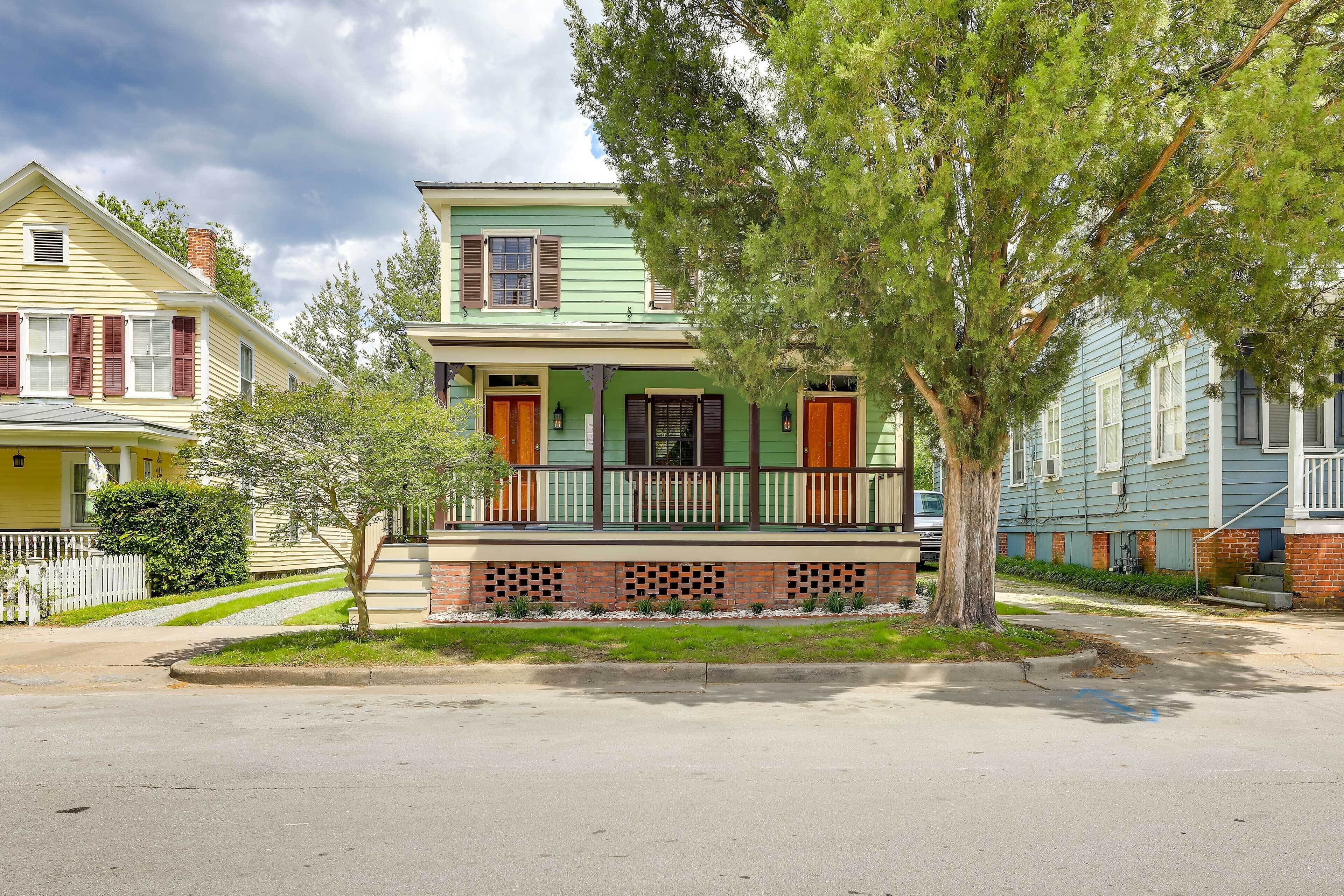 A two-story house with a front porch and a brick base.