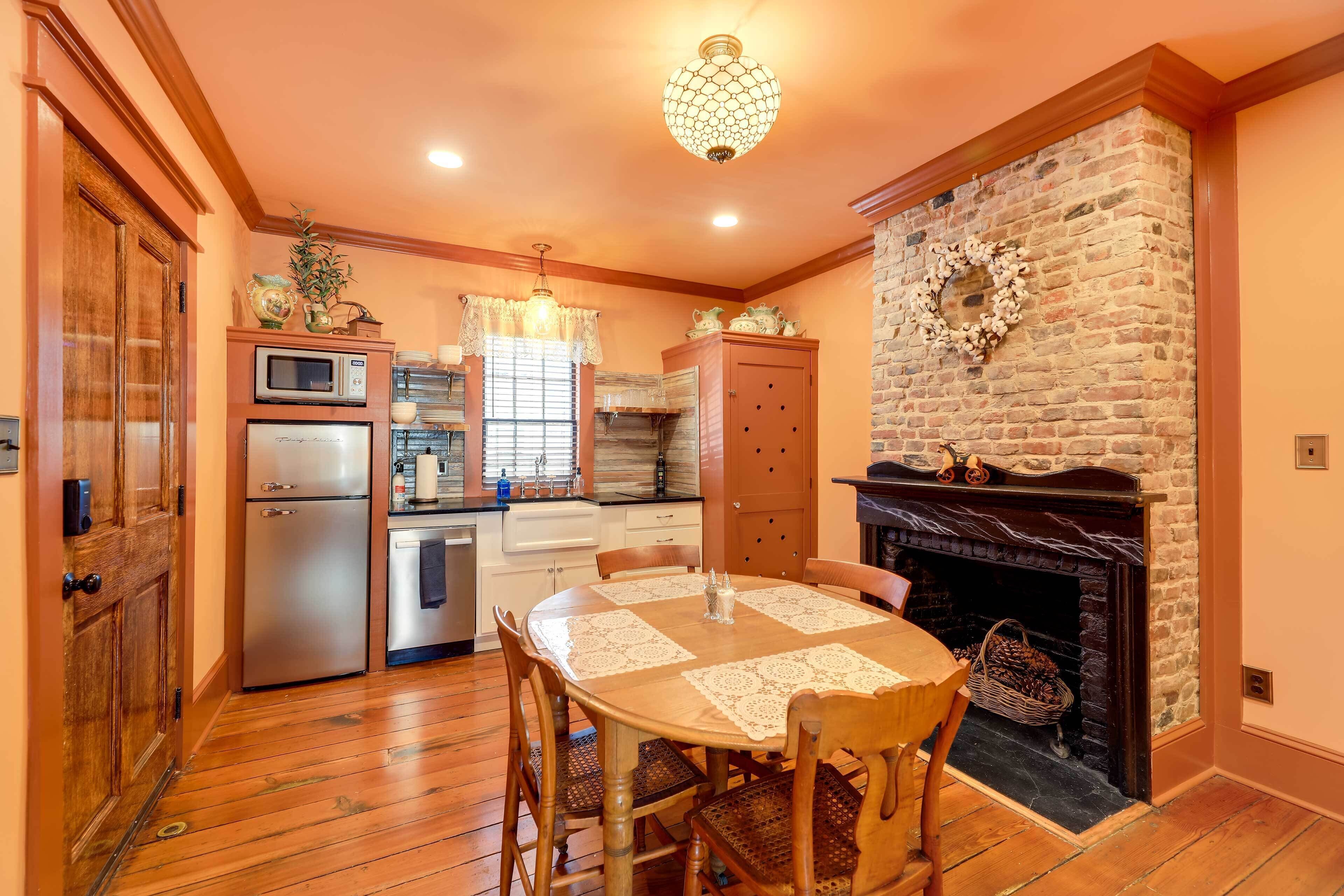 A cozy kitchen with a fireplace, wooden cabinets, and a dining table with chairs.