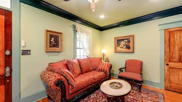A living room with a red sofa, a matching armchair, a round coffee table, and a patterned rug.