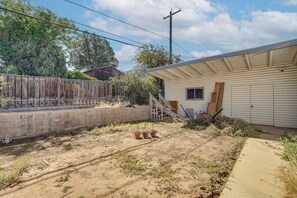 A residential area with a house, a wooden fence, and a dirt yard. - Walkable Home in Cedar City With Ample Parking (Cedar City)