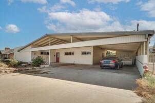 Una casa de un piso con garaje cubierto y entrada para vehículos.