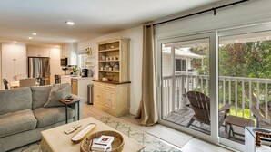 A modern living room with a sofa, coffee table, and a dining area with chairs. - Walk to Beach! Atlantic Beach Extended Stay (Atlantic Beach)