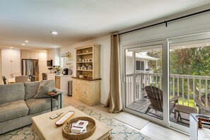 A modern living room with a sofa, coffee table, and a dining area with chairs. - Walk to Beach! Atlantic Beach Extended Stay (Atlantic Beach)
