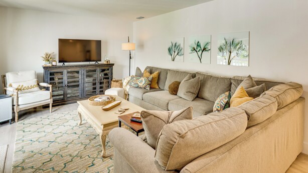A living room with a sofa, armchairs, a coffee table, a TV, and artwork on the wall. - Walk to Beach! Atlantic Beach Extended Stay (Atlantic Beach)