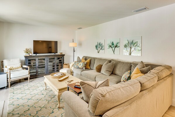 A living room with a sofa, armchairs, a coffee table, a TV, and artwork on the wall. - Walk to Beach! Atlantic Beach Extended Stay (Atlantic Beach)