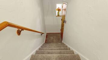 A staircase with a wooden handrail leading to a landing.
