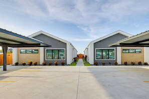 A modern building with a central pathway leading to a wooden fence. - 4 Mi to Dtwn Mcallen, Sleek Couples Condo! (McAllen)