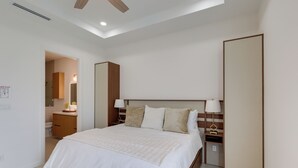 A hotel room with a bed, bedside tables, a mirror, and a ceiling fan. - Modern Couples Condo, 4 Mi to Downtown Mcallen! (McAllen)