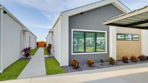 A modern residential building with a covered patio, a well-maintained lawn, and a clear sky. - Modern Couples Condo, 4 Mi to Downtown Mcallen! (McAllen)